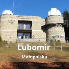 Obserwatorium astronomiczne na szczycie Lubomir, Małopolska. Kamienna budowla z kopułami, otoczona drzewami.