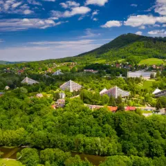 Ustroń atrakcje: widok z lotu ptaka na zielone wzgórza Beskidów, charakterystyczne budynki w kształcie piramid i inne obiekty architektoniczne.