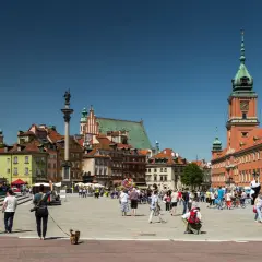 Warszawski Rynek Starego Miasta tętni życiem. Widać tu wiele zabytków w Polsce, w tym Zamek Królewski i Kolumnę Zygmunta.