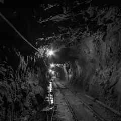 Wydobycie w kopalni złoty stok. Tunel kopalniany z torami i oświetleniem, prowadzący w głąb ziemi.