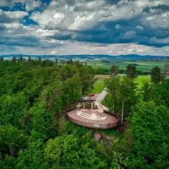 Widok z lotu ptaka na nowoczesną platformę widokową w otoczeniu lasu. To jedna z głównych radków atrakcji, oferująca wspaniałe panoramy.