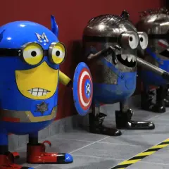 Miniony w strojach superbohaterów, w tym Kapitan Ameryka, czekają na zwiedzających w muzeum robotów Moszna.