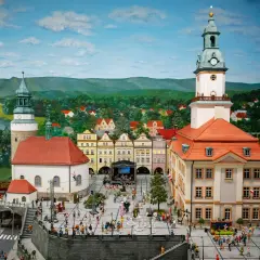 Miniaturowy rynek w Jeleniej Górze, z wieżą ratuszową, kamieniczkami i tłumem ludzi.