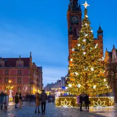 Świąteczna atmosfera w Gdańsku. Duża, oświetlona choinka i zabytkowe kamienice. Idealne miejsce, gdzie wyjechać na święta bożego narodzenia.