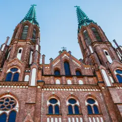 Imponująca ceglana bazylika z dwiema wieżami, ozdobiona oknami i krzyżami. Jeden z najpiękniejszych kościołów w Polsce.