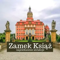 Zamek Książ w Wałbrzychu, imponująca budowla z wieżą i rzeźbami, otoczona zielenią.