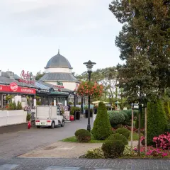 Ulica w Międzyzdrojach z restauracjami i kawiarniami, zielenią i ozdobnymi krzewami. Idealne miejsce na spacer i odkrywanie międzyzdrojskich atrakcji.