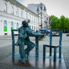 Pomnik siedzącego mężczyzny przy stoliku z kapeluszem, jedna z radomskich atrakcji.