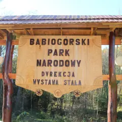 Drewniana tablica informacyjna Babiogórskiego Parku Narodowego. Zapowiada zawoja atrakcje i wystawę stałą.