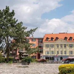Rynek w Sobótce z kamienną rzeźbą i kolorowymi kamienicami. Idealne miejsce na spacer i odkrywanie lokalnych atrakcji.