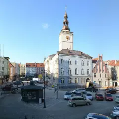 Rynek w Dzierżoniowie z ratuszem i kolorowymi kamienicami. Atrakcje miasta widoczne w słoneczny dzień.