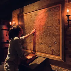 Dziewczyna studiuje starą mapę, szukając wskazówek w escape roomie we Wrocławiu.