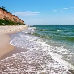 Plaża w Sarbinowie z klifem i zielenią. Idealne miejsce na relaks i odkrywanie atrakcji nad morzem.
