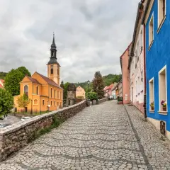 Kolorowy rynek w miasteczku, z pomarańczową świątynią i niebieskim budynkiem.