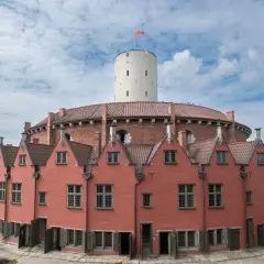 Gdańsk atrakcje dla dorosłych: Twierdza Wisłoujście z charakterystyczną wieżą i ceglanymi budynkami. Idealne miejsce na spacer i odkrywanie historii.