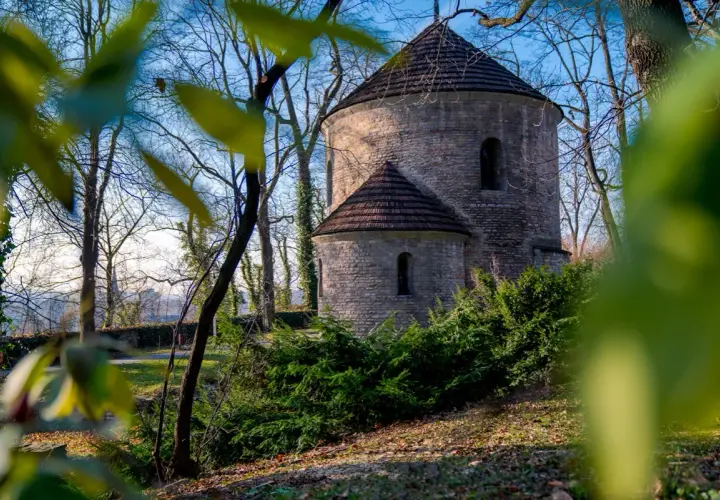 Kamienna rotunda w Cieszynie, jedna z jego atrakcji, otoczona drzewami i zielenią.
