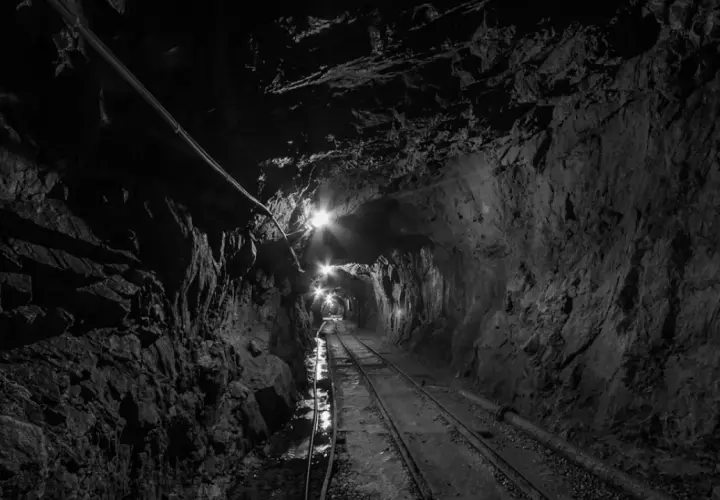 Wydobycie w kopalni złoty stok. Tunel kopalniany z torami i oświetleniem, prowadzący w głąb ziemi.