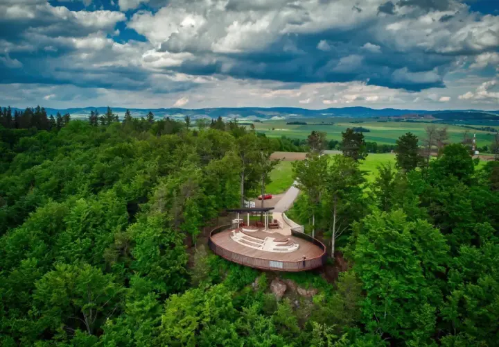 Widok z lotu ptaka na nowoczesną platformę widokową w otoczeniu lasu. To jedna z głównych radków atrakcji, oferująca wspaniałe panoramy.