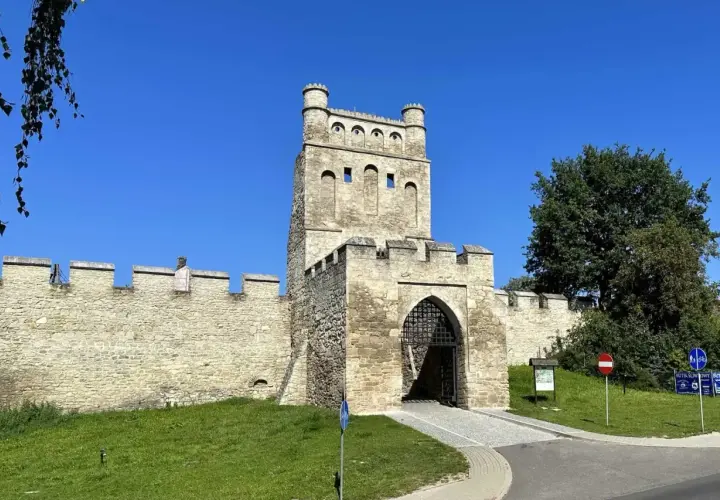Kamienna brama z wieżą, przypominająca polskie Carcassonne, strzeże wejścia do zabytkowego miasta.