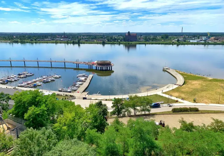 Nowoczesna marina i promenada nad rzeką, z widokiem na miasto. To jedne z wielu **ciekawych miejsc na Mazowszu**, idealnych na letni wypoczynek.