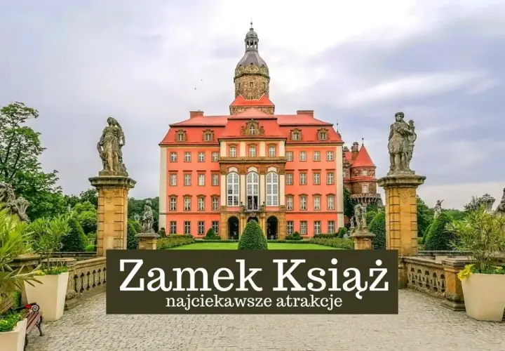 Zamek Książ w Wałbrzychu, imponująca budowla z wieżą i rzeźbami, otoczona zielenią.