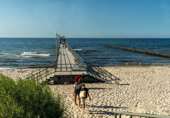Spacerem po molo, podziwiając morze i plażę. To jedne z wielu atrakcji Sianożętów.