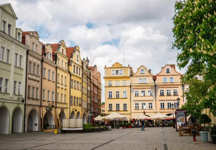 Kolorowe kamienice na rynku w Jeleniej Górze, z arkadami i ogródkami kawiarnianymi. Atrakcje miasta czekają!