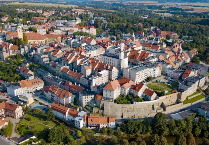 Widok z lotu ptaka na urokliwe miasto Bystrzyca Kłodzka z charakterystycznymi czerwonymi dachami i zabytkową architekturą.