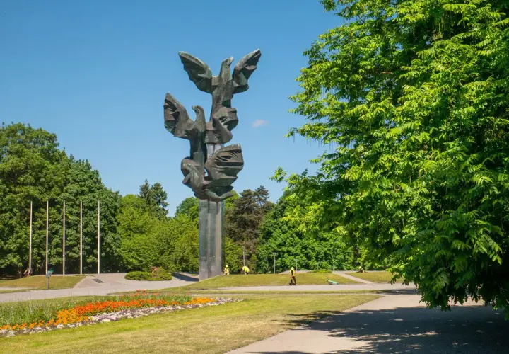 Pomnik Czynu Polaków w Szczecinie, jedna z głównych atrakcji miasta, w otoczeniu zieleni i kwitnących kwiatów.