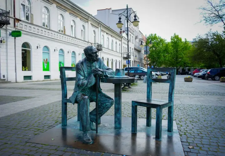 Pomnik siedzącego mężczyzny przy stoliku z kapeluszem, jedna z radomskich atrakcji.