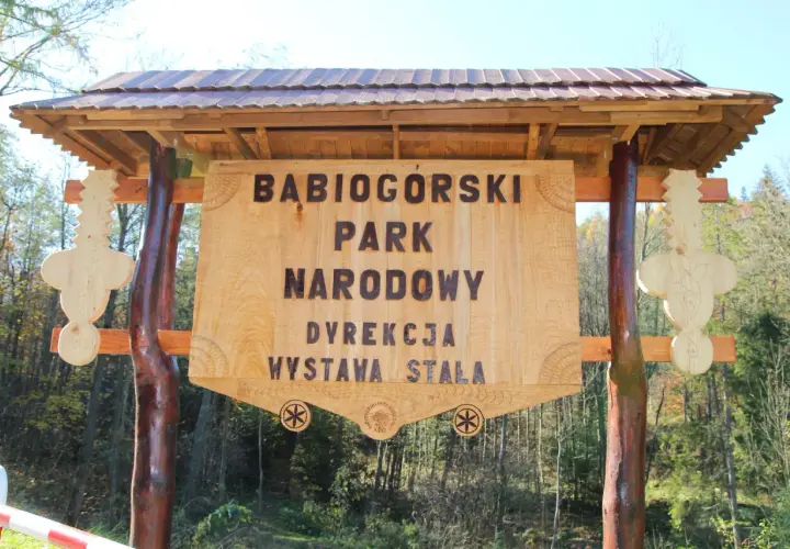 Drewniana tablica informacyjna Babiogórskiego Parku Narodowego. Zapowiada zawoja atrakcje i wystawę stałą.