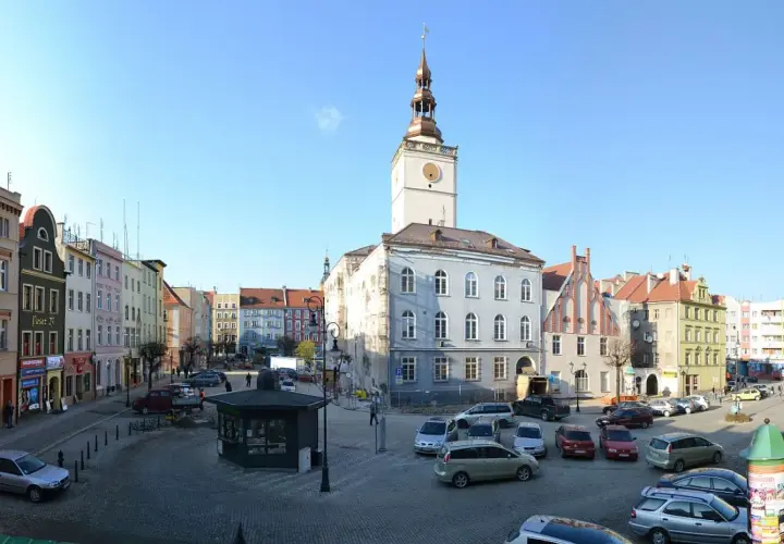 Rynek w Dzierżoniowie z ratuszem i kolorowymi kamienicami. Atrakcje miasta widoczne w słoneczny dzień.