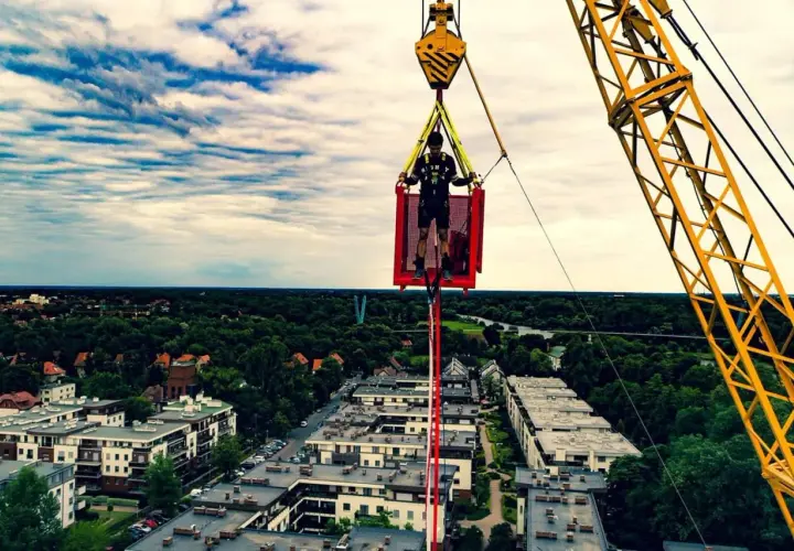 Ostatnie przygotowania przed skokiem bungee we Wrocławiu. Mężczyzna w koszu dźwigu, gotowy na adrenalinę.