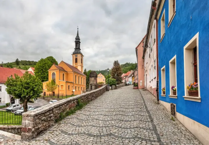 Kolorowy rynek w miasteczku, z pomarańczową świątynią i niebieskim budynkiem.