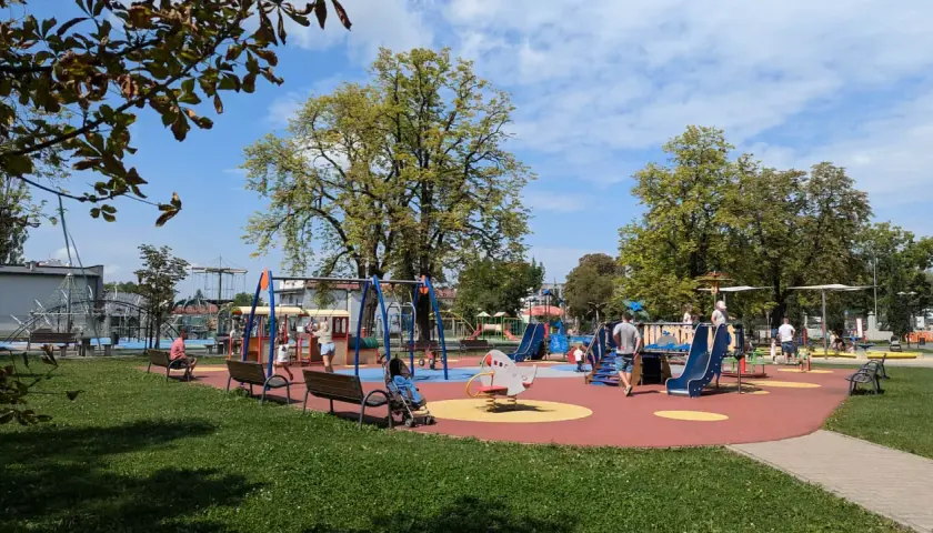 Kolorowy plac zabaw w Tarnowie, pełen śmiechu dzieci i zieleni. Wspaniałe tarnowskie atrakcje dla najmłodszych.