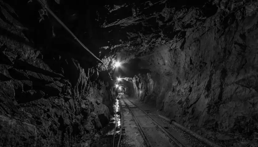Wydobycie w kopalni złoty stok. Tunel kopalniany z torami i oświetleniem, prowadzący w głąb ziemi.