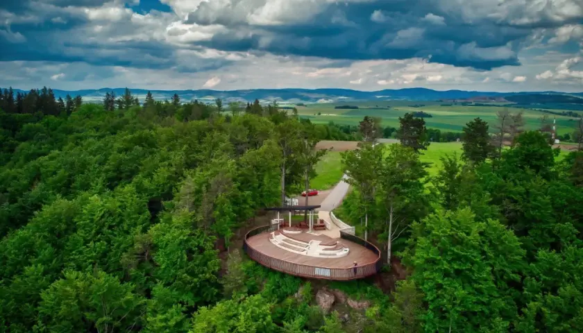 Widok z lotu ptaka na nowoczesną platformę widokową w otoczeniu lasu. To jedna z głównych radków atrakcji, oferująca wspaniałe panoramy.