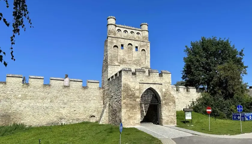 Kamienna brama z wieżą, przypominająca polskie Carcassonne, strzeże wejścia do zabytkowego miasta.