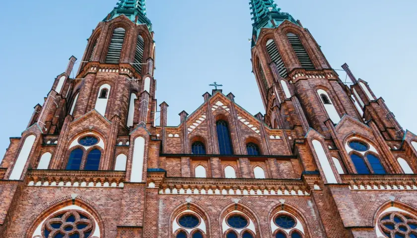 Imponująca ceglana bazylika z dwiema wieżami, ozdobiona oknami i krzyżami. Jeden z najpiękniejszych kościołów w Polsce.
