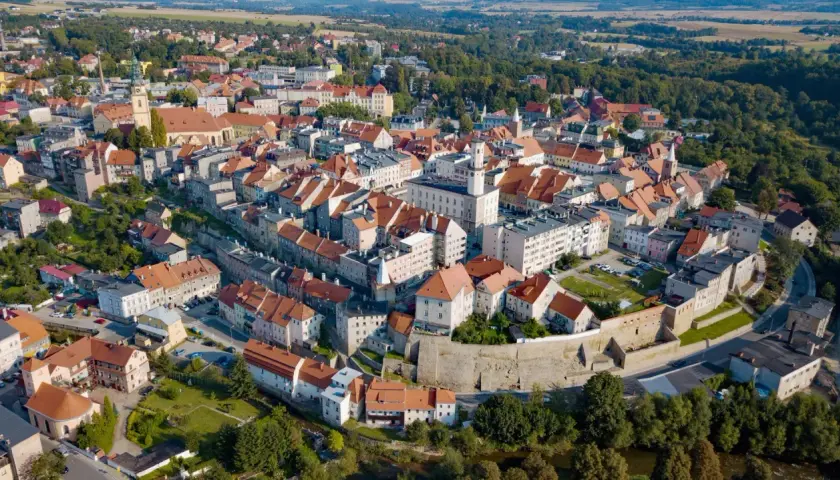 Widok z lotu ptaka na urokliwe miasto Bystrzyca Kłodzka z charakterystycznymi czerwonymi dachami i zabytkową architekturą.
