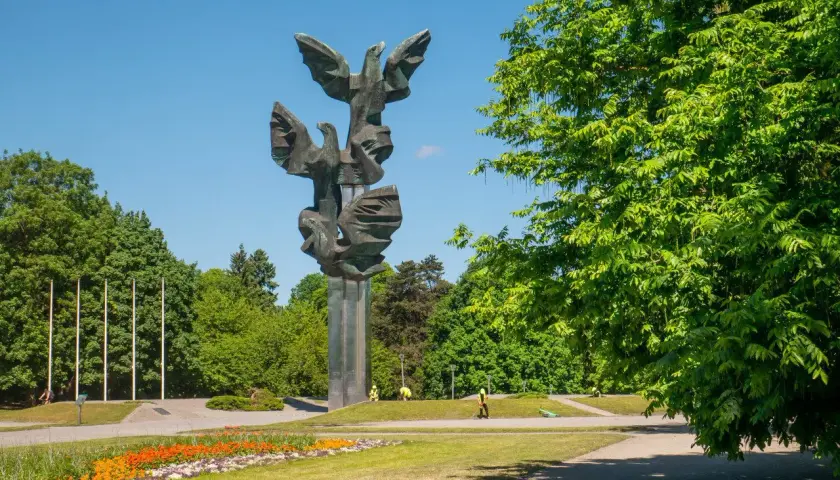 Pomnik Czynu Polaków w Szczecinie, jedna z głównych atrakcji miasta, w otoczeniu zieleni i kwitnących kwiatów.