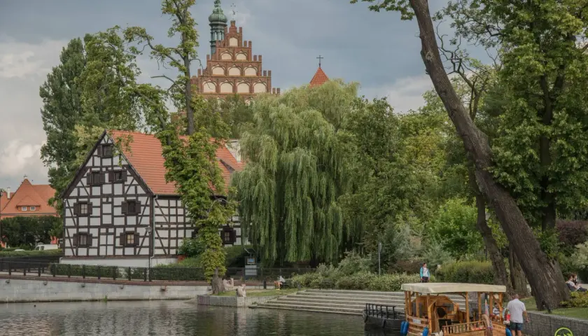 Urokliwe zakątki Kujaw i Pomorza: zabytkowa zabudowa, malownicza rzeka i łódź spacerowa. Odkryj atrakcje regionu!