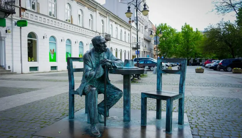 Pomnik siedzącego mężczyzny przy stoliku z kapeluszem, jedna z radomskich atrakcji.