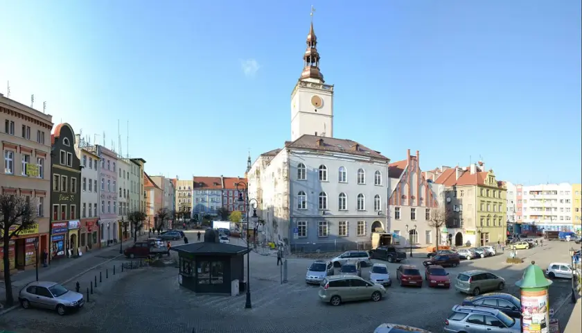 Rynek w Dzierżoniowie z ratuszem i kolorowymi kamienicami. Atrakcje miasta widoczne w słoneczny dzień.