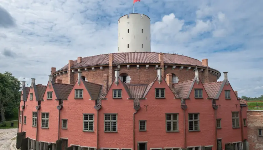 Gdańsk atrakcje dla dorosłych: Twierdza Wisłoujście z charakterystyczną wieżą i ceglanymi budynkami. Idealne miejsce na spacer i odkrywanie historii.