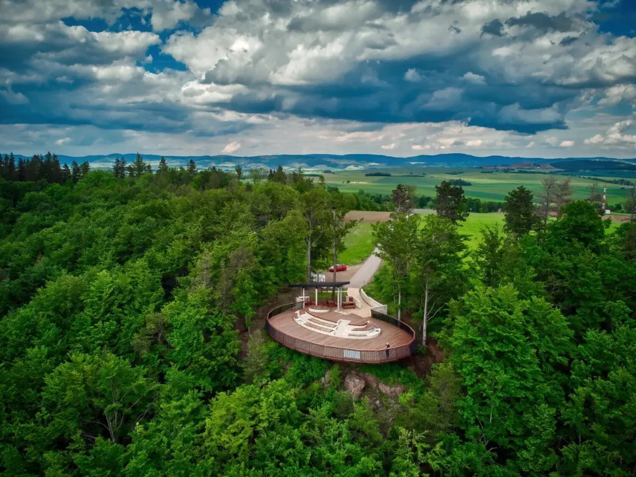 Widok z lotu ptaka na nowoczesną platformę widokową w otoczeniu lasu. To jedna z głównych radków atrakcji, oferująca wspaniałe panoramy.