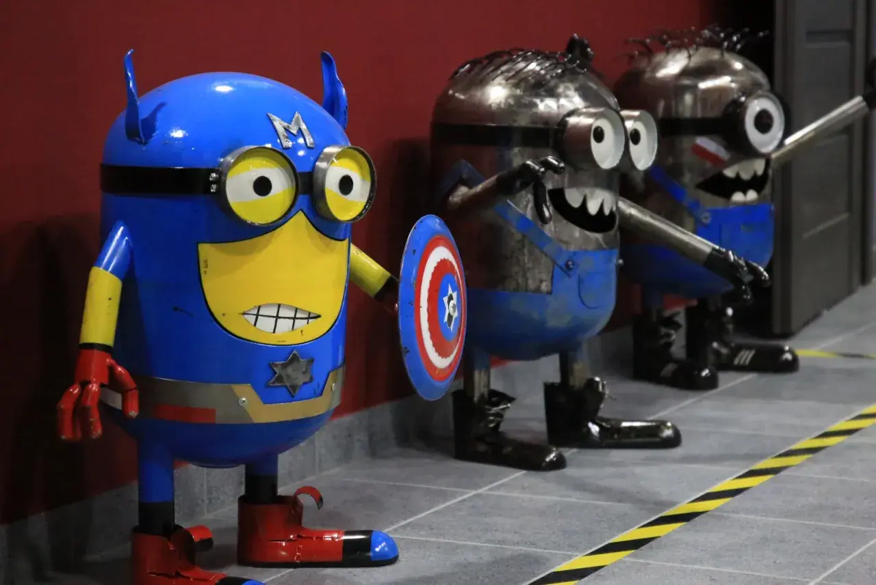 Miniony w strojach superbohaterów, w tym Kapitan Ameryka, czekają na zwiedzających w muzeum robotów Moszna.