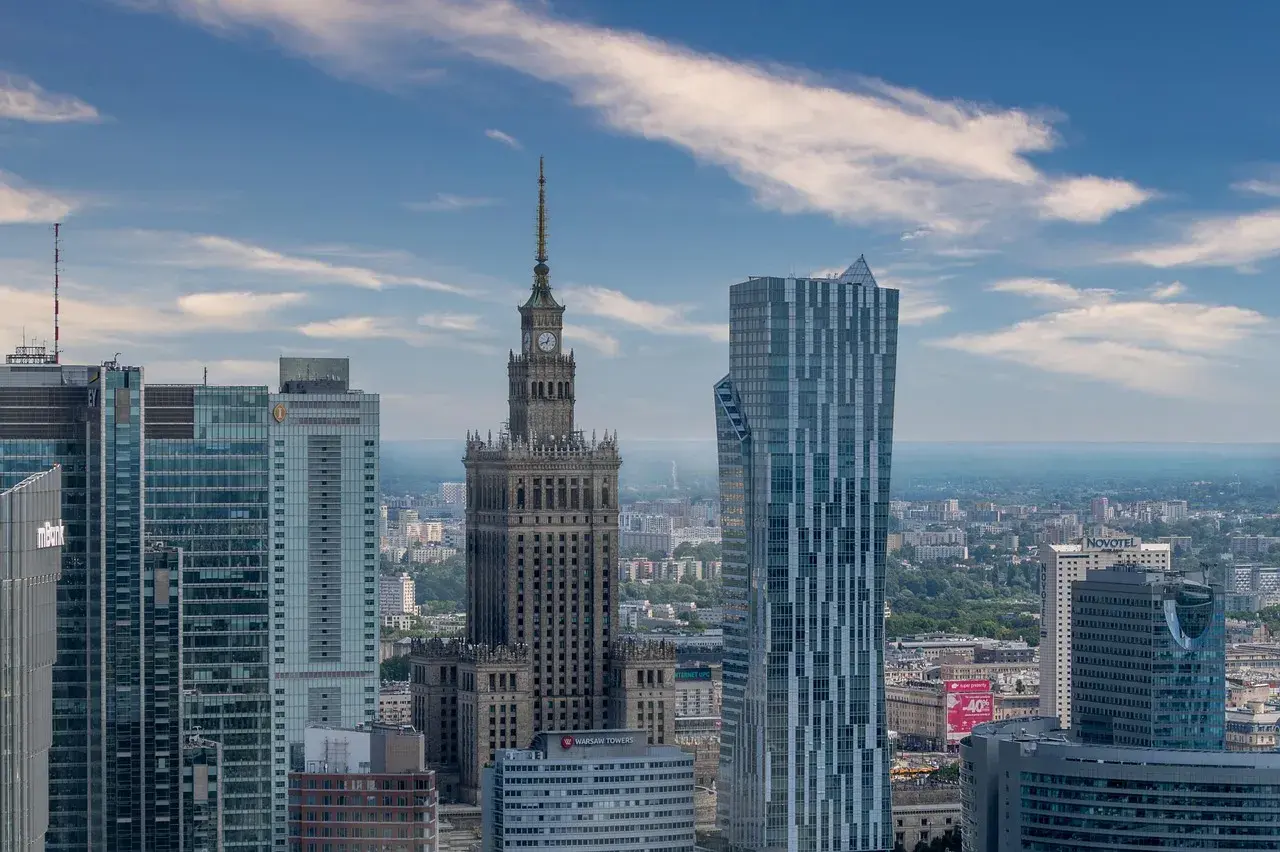 Warszawa atrakcje: Pałac Kultury i Nauki góruje nad nowoczesnymi wieżowcami, tworząc panoramę stolicy.