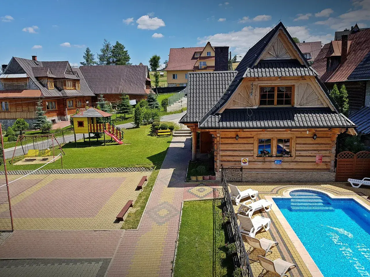 Murzasichle atrakcje: basen, plac zabaw, boisko do siatkówki i drewniane domki. Idealne miejsce na wypoczynek.
