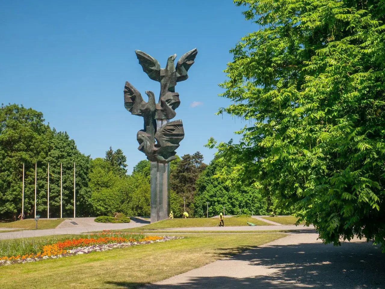 Pomnik Czynu Polaków w Szczecinie, jedna z głównych atrakcji miasta, w otoczeniu zieleni i kwitnących kwiatów.